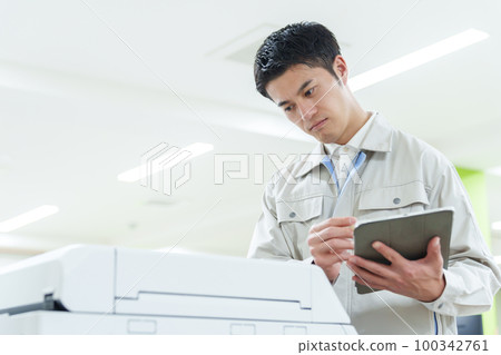 Worker who inspects copy machine Worker who inspects copy machine 100342761