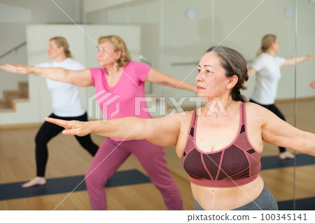 Ladies are doing warrior II pose Ladies are doing warrior II pose 100345141