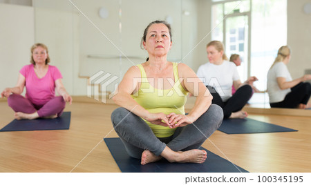 Three women are sitting in a lotus pose Three women are sitting in a lotus pose 100345195
