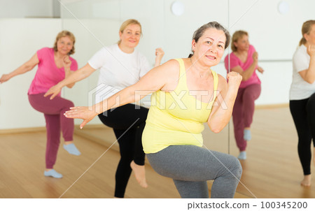 Mature woman training at group dance class Mature woman training at group dance class 100345200