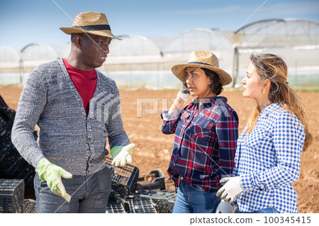 Farmer talking to female workers Farmer talking to female workers 100345415