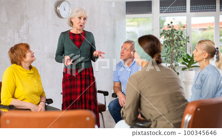 Aged woman conducting language speaking club for older adults Aged woman conducting language speaking club for older adults 100345646