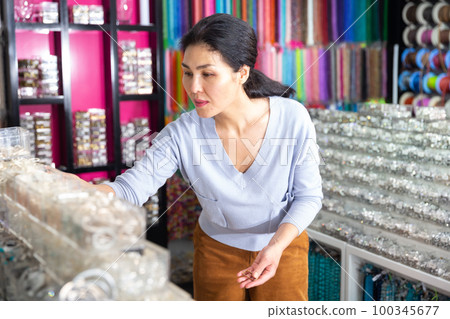 Asian woman shopping and searching adornments in boutique Asian woman shopping and searching adornments in boutique 100345677