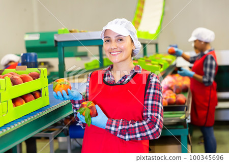 Portrait of glad woman with peaches 100345696