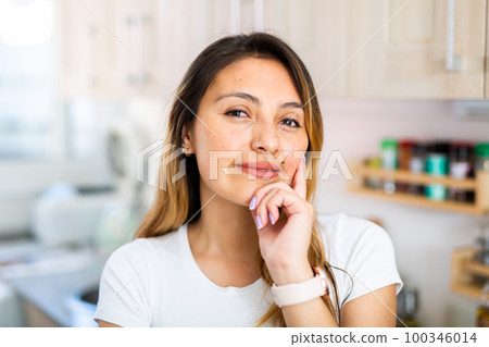 Latino housewife standing at home kitchen 100346014