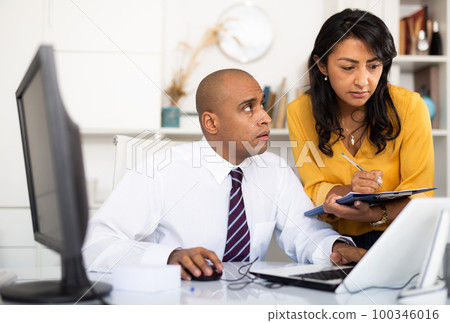 Directors assistant makes daily routine and writes down instructions in office 100346016