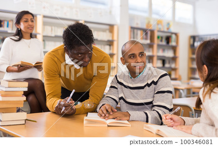 Group of adult people studying in library 100346081
