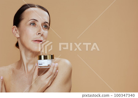 modern 40 years old woman against beige background modern 40 years old woman against beige background 100347340