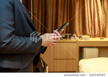 Female business looking at smartphone indoors 100349365