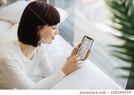 Happy woman buying cosmetics on sale online using mobile 100349479