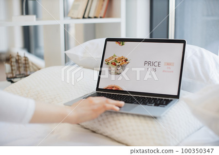 Woman with laptop ordering salad with discount online 100350347