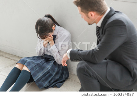 老師和男生在學校教室里安慰哭泣的高中女生和初中生 老師和男生在學校教室里安慰哭泣的高中女生和初中生 100354087