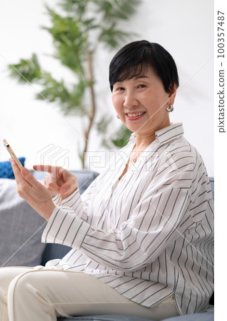 Senior woman smartphone payment Senior woman smartphone payment 100357487