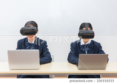 Junior high school and high school girls wearing VR goggles and playing PC games and studying (VR AR MR) Junior high school and high school girls wearing VR goggles and playing PC games and studying (VR AR MR) 100358555