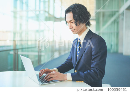 A businessman working on a personal computer 100359461