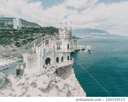 Crimea Swallow's Nest Castle on the rock over the Black Sea. It is a tourist attraction of Crimea. Amazing aerial view of the Crimea coast with the castle above abyss on sunny day. 100359513