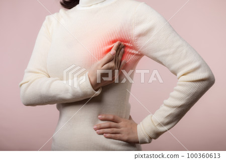 Woman hands checking lumps on her breast for signs of breast cancer on pink background. Healthcare concept. Woman hands checking lumps on her breast for signs of breast cancer on pink background. Healthcare concept. 100360613