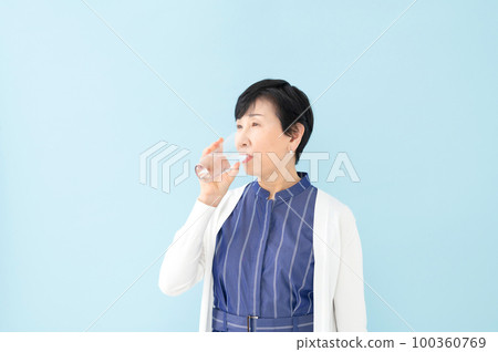 Senior woman drinking water 100360769