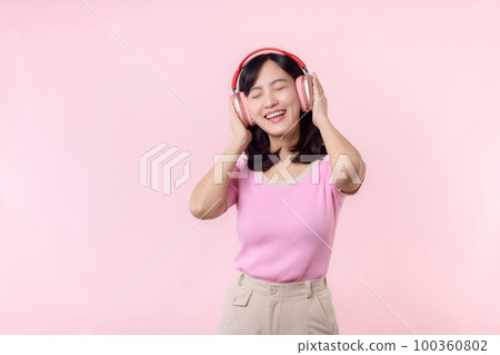 Smile pretty model person listen music song and enjoy dance with wireless headphone online audio radio sound. Positive fun exited joyful youth female woman sing on pink isolated background studio Smile pretty model person listen music song and enjoy dance with wireless headphone online audio radio sound. Positive fun exited joyful youth female woman sing on pink isolated background studio 100360802