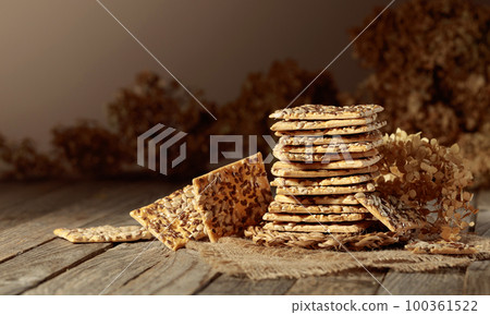 Crackers with sunflower and flax seeds on an old wooden table. Crackers with sunflower and flax seeds on an old wooden table. 100361522