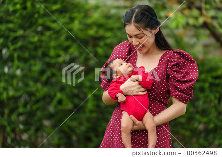 mother holding and playing with baby newborn in the garden mother holding and playing with baby newborn in the garden 100362498