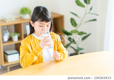 Elementary school girl drinking mineral water Elementary school girl drinking mineral water 100363615