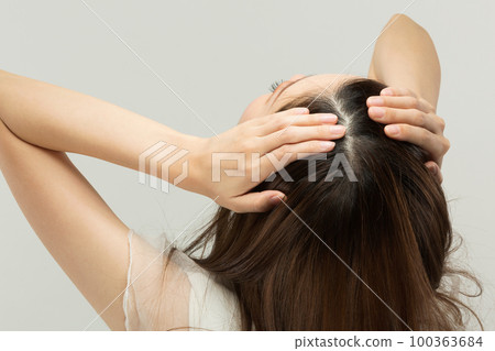 A close-up of a young woman's scalp. 100363684