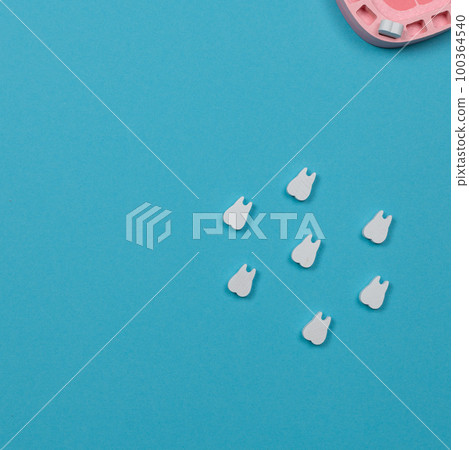 Toy wooden teeth on a blue background, top view, copy space. Toy wooden teeth on a blue background, top view, copy space. 100364540