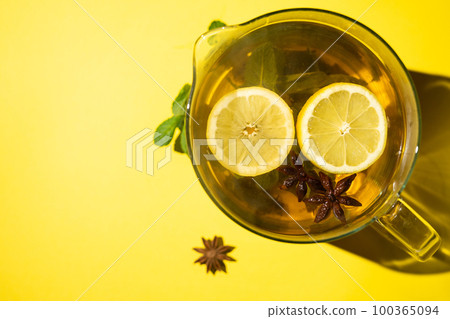 Green tea with lemon mint and star anise on a yellow background. Green tea with lemon mint and star anise on a yellow background. 100365094