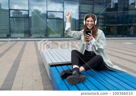 young female student listening to music on app during study break 100366010
