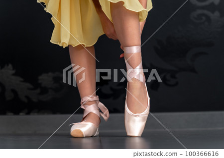 ballet shoes on the feet of a ballerina. close up 100366616