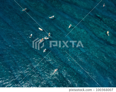 Aerial view of surfers in ocean. Surfing spot in tropical island Aerial view of surfers in ocean. Surfing spot in tropical island 100368007