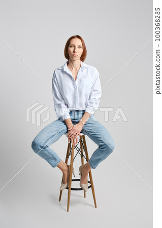 Portrait of middle aged caucasian redhead woman in white shirt and blue jeans Portrait of middle aged caucasian redhead woman in white shirt and blue jeans 100368285