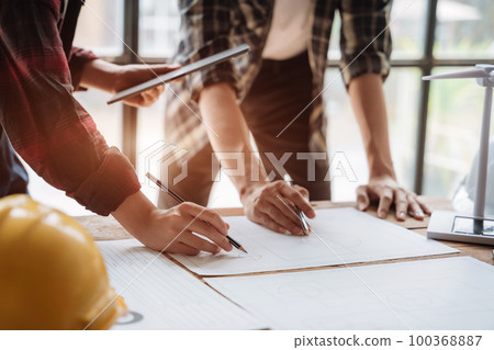 architect  working on table use drawing tool on the paper plan for business architectural project. 100368887