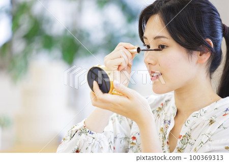 A woman applying mascara A woman applying mascara 100369313