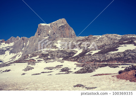 The top of the mountain, covered in snow in the summer. Mountain landscape on a sunny day. Beautiful nature, snowy landscape. Fuente De, Spain 100369335