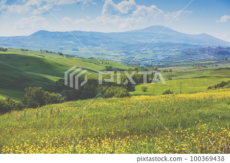 Beautiful landscape, spring nature. Mountain landscape. Top view of sunny fields on the hills in Tuscany, Italy Beautiful landscape, spring nature. Mountain landscape. Top view of sunny fields on the hills in Tuscany, Italy 100369438