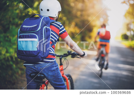 Children riding on bicycles on asphalt road in summer. 100369686