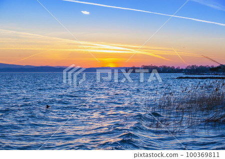 Early morning, sunrise over the lake. Garda lake (Lago di Garda), Italy, Europe Early morning, sunrise over the lake. Garda lake (Lago di Garda), Italy, Europe 100369811