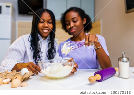 Happy loving same sex couple is preparing the pastry in the kitchen Happy loving same sex couple is preparing the pastry in the kitchen 100370118