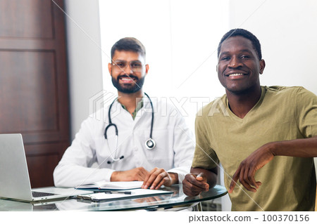 doctor and male patient talking at office consultation for further treatment 100370156