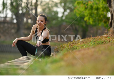 Active sporty woman stretching her legs before morning workout. Fitness, sport and healthy lifestyle concept Active sporty woman stretching her legs before morning workout. Fitness, sport and healthy lifestyle concept 100372067
