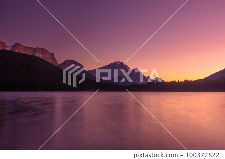 Lake and mountains in a valley at dawn. Reflections on the surface of the lake. 100372822