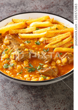 Khoresh Gheymeh is a Beef and Split Pea Stew with saffron potatoes closeup on a plate. Vertical 100372863
