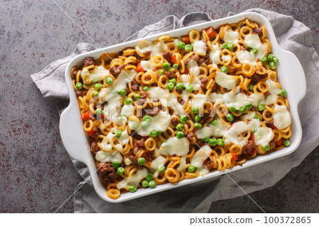 Anelli al Forno pasta baked with cheese, ground beef, vegetables close-up in a baking dish. Horizontal top view Anelli al Forno pasta baked with cheese, ground beef, vegetables close-up in a baking dish. Horizontal top view 100372865