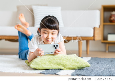 在智能手機上觀看視頻的小學生 在智能手機上觀看視頻的小學生 100373439