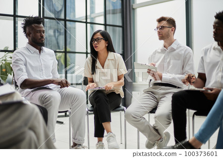 colleagues discussing possible questions for speakers before political summit in conference hall 100373601