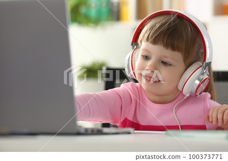 Portrait of a little child girl in headphones with laptop Portrait of a little child girl in headphones with laptop 100373771