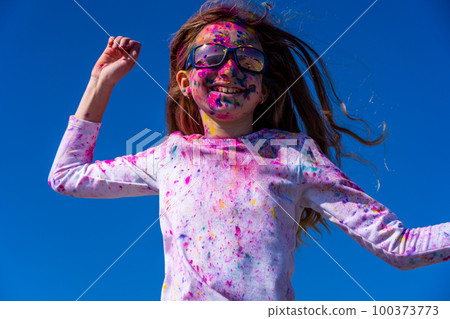 Young european girl celebrating holy festival on a blue sky background Young european girl celebrating holy festival on a blue sky background 100373773