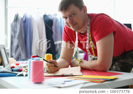 Male fashion designer working in studio in atelier Male fashion designer working in studio in atelier 100373776